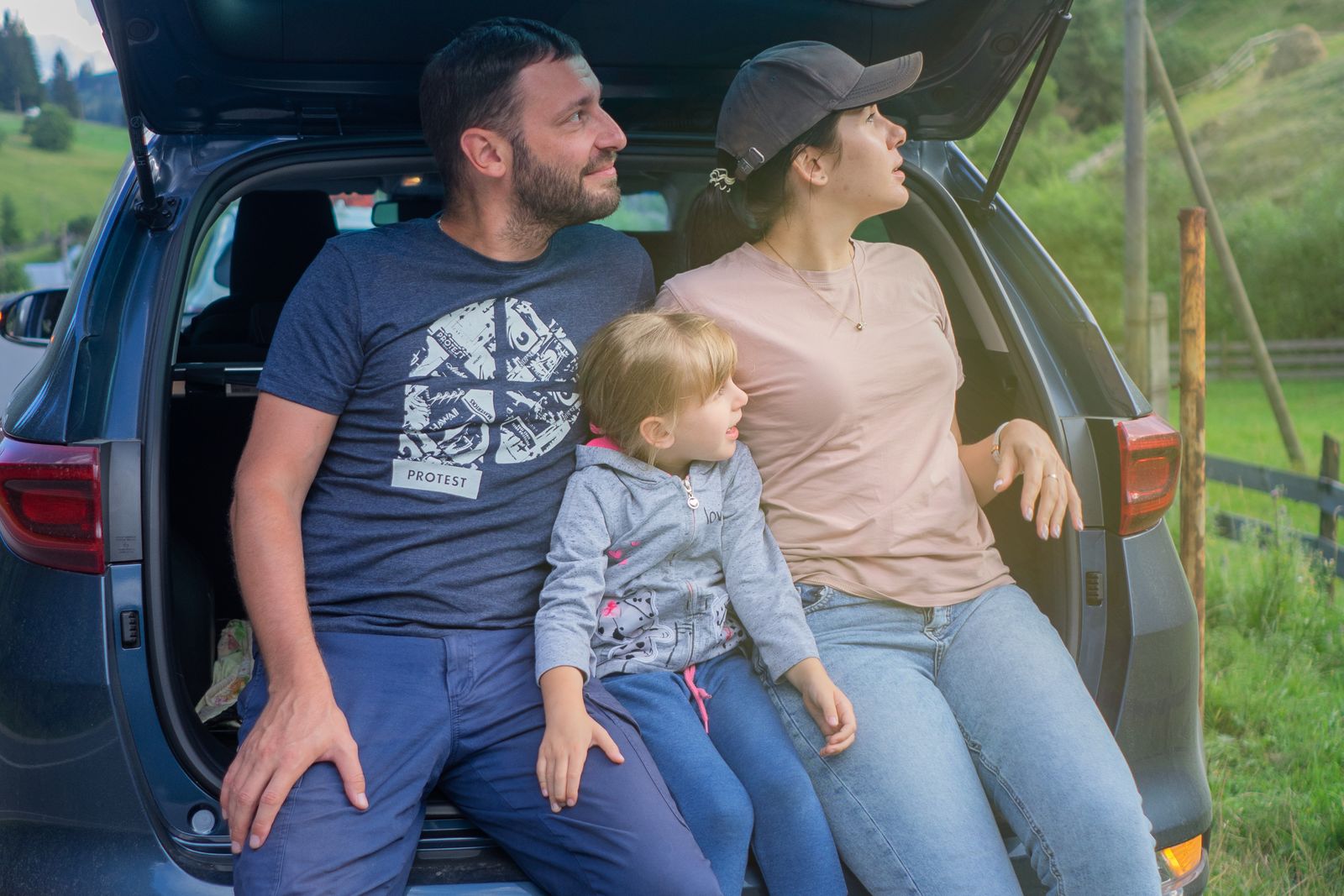 Family sitting in the back of their SUV on a day out