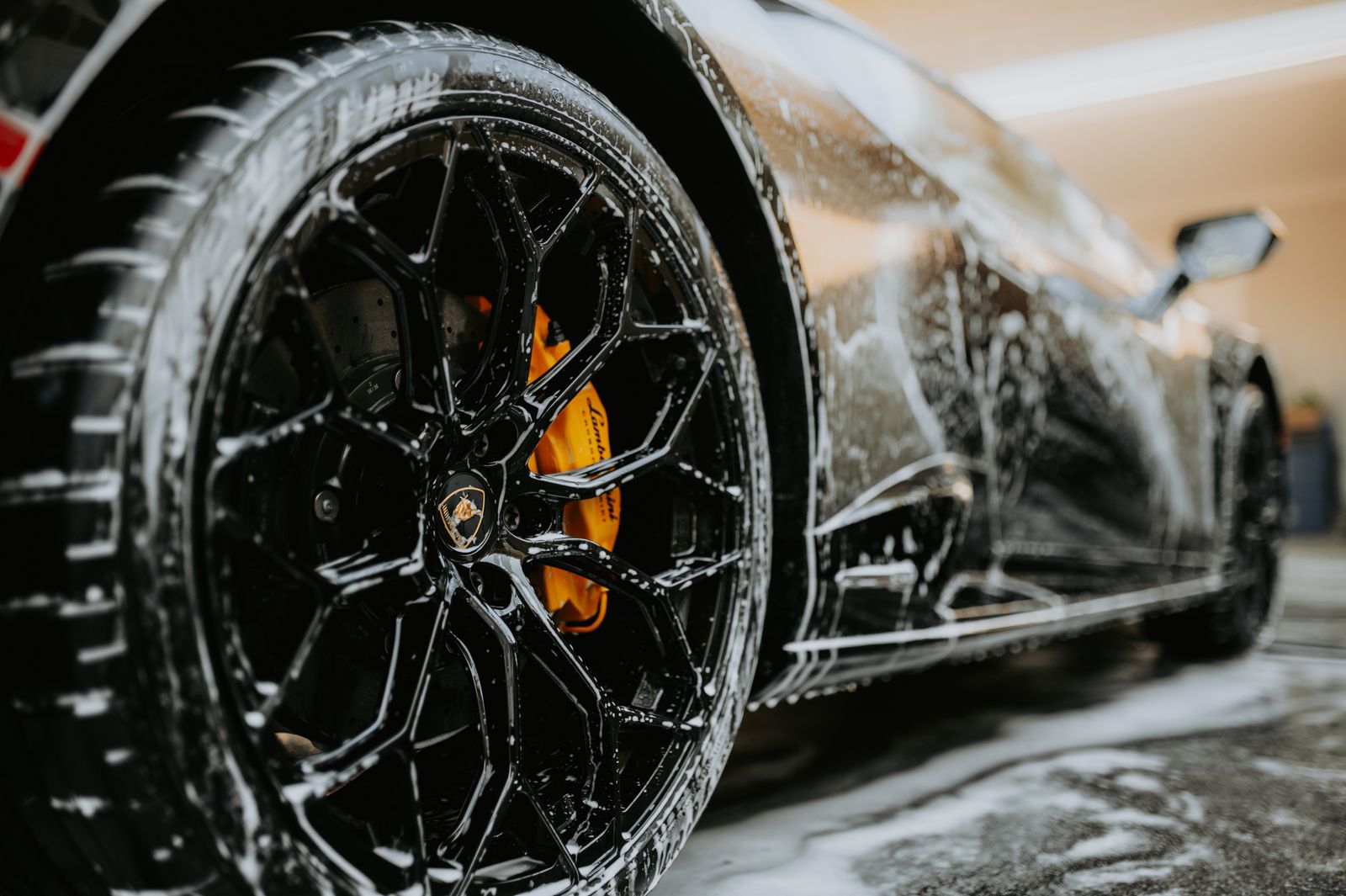 Wheel covered in cleaner suds during a wash