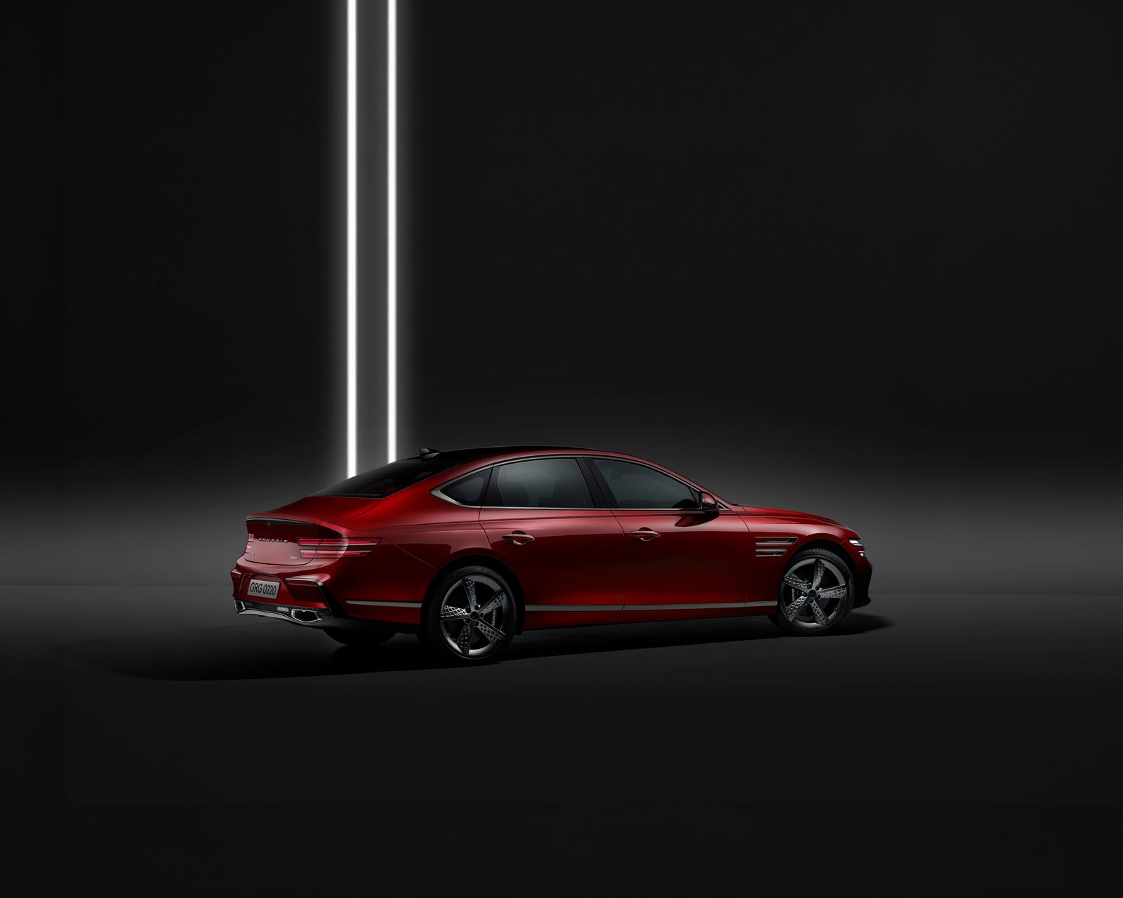 A striking red luxury sedan showcased against a minimalist backdrop with modern lighting.