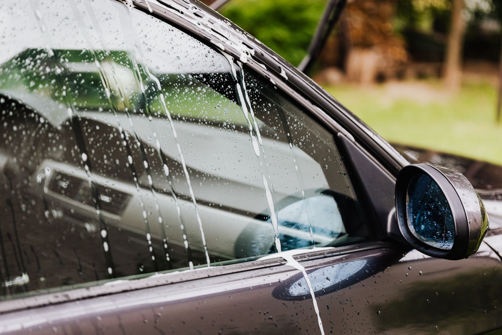 Car window with soap and water at the wash